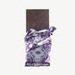 Vosges Black Salt Caramel bar unwrapped stands upright on a white background.